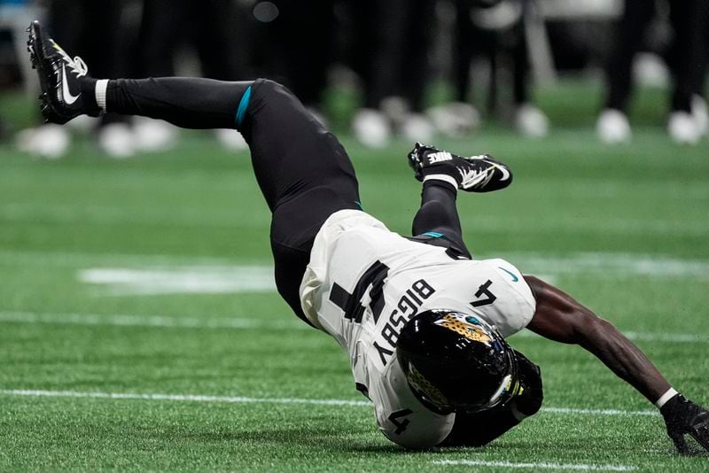 Jacksonville Jaguars running back Tank Bigsby (4) falls to the turf after a run against the Atlanta Falcons in the first half of an NFL preseason footballl game, Friday, Aug. 23, 2024, in Atlanta. (AP Photo/John Bazemore)