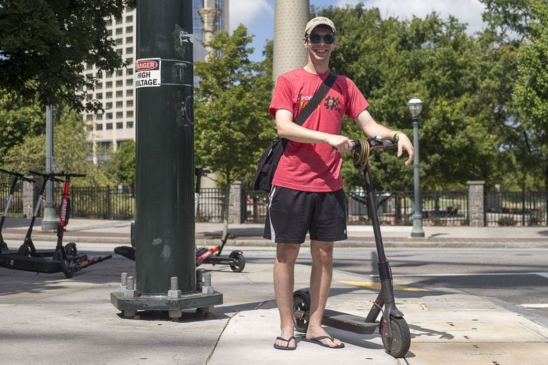 Midtown resident Jeff Peterson stands with his personal motorized scooter near Centennial Olympic Park in Atlanta, Tuesday, August 20, 2019. (Alyssa Pointer/alyssa.pointer@ajc.com)