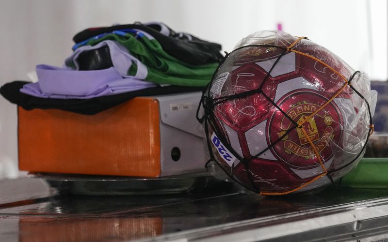 A newly purchased football is kept near the coffin of one of the victims of the school bus fire by father Wichan Seubsaichan, at Wat Khao Phraya Sangkharam School, Lan Sak, Uthai Thani province, Thailand, Thursday, Oct. 3, 2024. (AP Photo/Sakchai Lalit)