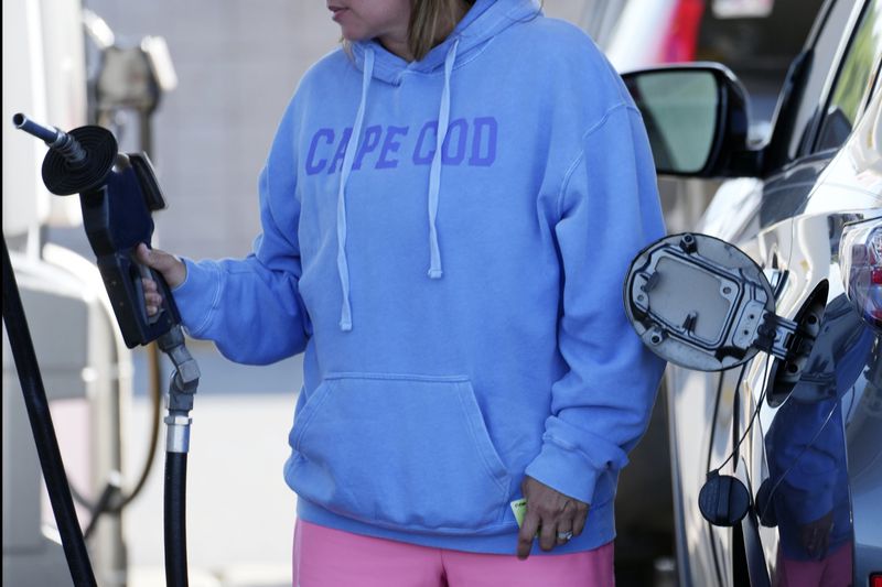 FILE - A woman fuels her car at the gateway to Cape Cod in Sagamore, Mass., Aug. 30, 2024. (AP Photo/Michael Dwyer, File)