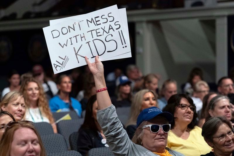 An attendee holds up a sign at the Moms for Liberty National Summit in Washington, Saturday, Aug. 31, 2024. (AP Photo/Jose Luis Magana)