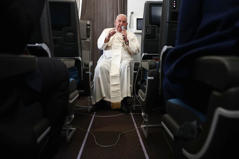 Pope Francis holds a news conference aboard the papal plane on his flight back after his 12-day journey across Southeast Asia and Oceania, Friday, Sept. 13, 2024. (Guglielmo Mangiapane/Pool Photo via AP)