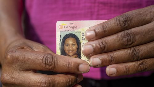 Courtney Brown of College Park holds her Georgia driver's license. Brown's driver's license is not on file with election officials, meaning she would have to submit additional documentation, such as a utility bill or bank statement, to to cast an absentee ballot, according to Georgia’s new voting law. (Alyssa Pointer / Alyssa.Pointer@ajc.com)