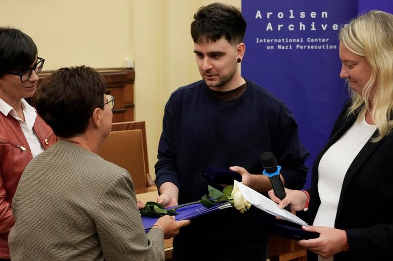 A relative shows golden jewelry that was confiscated by Nazi Germans from Zofia Strusińska and her sister Józefa Skórka, who were captured by Nazi troops during Warsaw Uprising in 1944 and taken to a forced labor camp. Their seized items that had been stored at Germany's Arolsen Archives, were returned to their relatives in a ceremony in Warsaw, Poland, on Tuesday, Sept. 10, 2024, in which 10 other families also had belongings of their relatives returned. (AP Photo/Czarek Sokolowski)