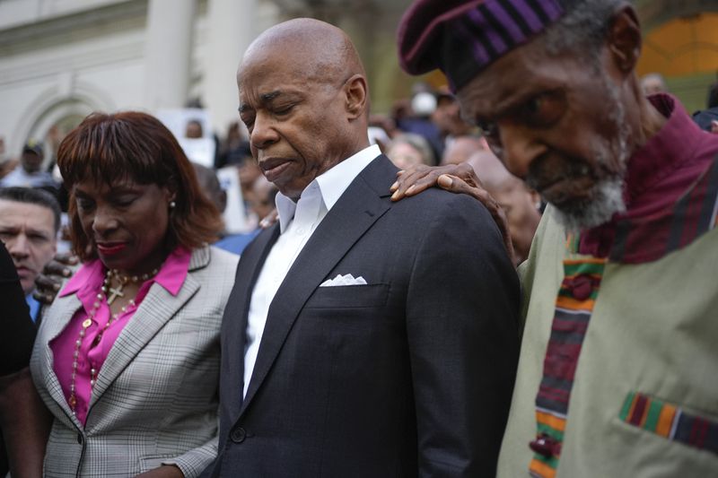 Faith leaders and other supporters pray over New York City Mayor Eric Adams, center, during a rally and prayer vigil on the steps of City Hall in New York, Tuesday, Oct. 1, 2024. (AP Photo/Seth Wenig)