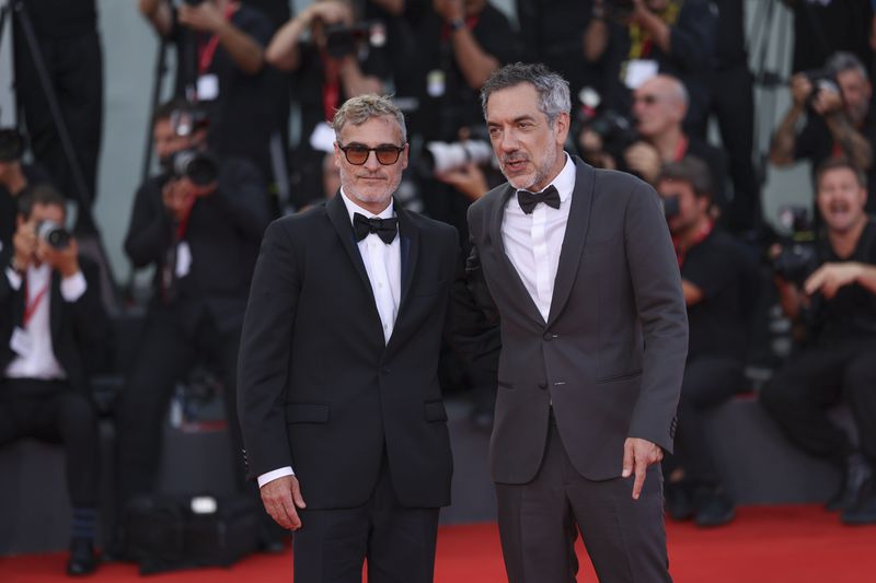 Joaquin Phoenix, left, and director Todd Phillips pose for photographers upon arrival for the premiere of the film 'Joker: Folie A Deux' during the 81st edition of the Venice Film Festival in Venice, Italy, on Wednesday, Sept. 4, 2024. (Photo by Vianney Le Caer/Invision/AP)