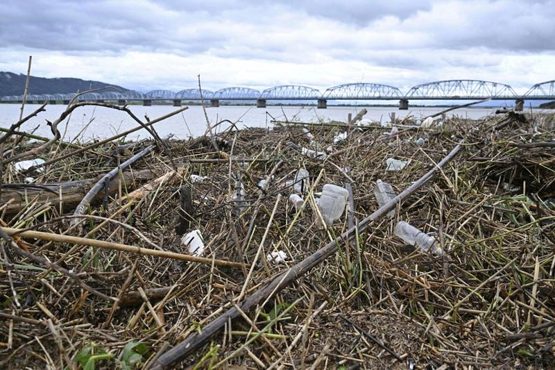 Flood debris is seen piled on the bank of the Yoshino river in Tokushima, southern Japan, Saturday, Aug. 31, 2024, following a tropical storm in the area. (Yusuke Hashizume/Kyodo News via AP)