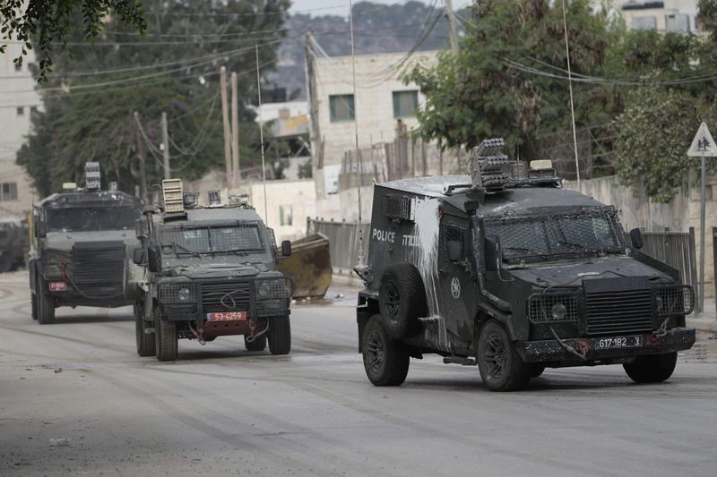 Israeli armoured vehicles move on a street during a military operation in the West Bank city of Jenin, Wednesday, Aug. 28, 2024. (AP Photo/Majdi Mohammed)