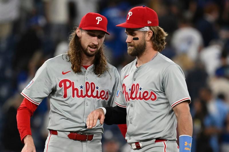 Philadelphia Phillies pitcher Matt Strahm, left, and Bryce Harper celebrate their team's victory over the Toronto Blue Jays in a baseball game in Toronto on Tuesday Sept. 3, 2024. (Jon Blacker/The Canadian Press via AP)