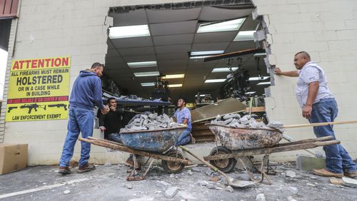 Workers with N.B. Masonry worked to fix a hole at Gable Sporting Goods in Douglasville.