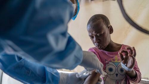 FILE - A health worker attends to a mpox patient, at a treatment centre in Munigi, eastern Congo, Aug. 19, 2024. (AP Photo/Moses Sawasawa, File)