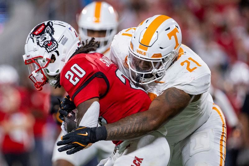 North Carolina State running back Hollywood Smothers (20) is tacked by Tennessee defensive lineman Omari Thomas (21) during the first half of an NCAA college football game Saturday, Sept. 7, 2024, in Charlotte, N.C. (AP Photo/Scott Kinser)