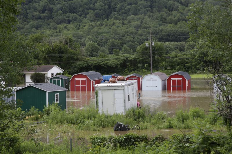 Water floods the lower level of homes, Thursday, July 11, 2024, in Bolton, Vt., near the Winooski River. (AP Photo/Hasan Jamali)