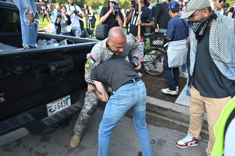 Protesters fight with each other after a rally during the Democratic National Convention Monday, Aug. 19, 2024, in Chicago. (AP Photo/Noah Berger)