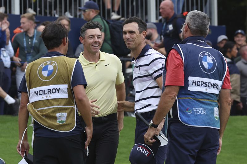 Billy Horschel of the United States, second right shakes hands with Rory McIlroy, of Northern Ireland, second left, on the 18th green with Horschel winning a playoff to win the British PGA golf Championship at Wentworth golf club in Wentworth, England, Sunday, Sept. 22, 2024. (AP Photo/Ian Walton)