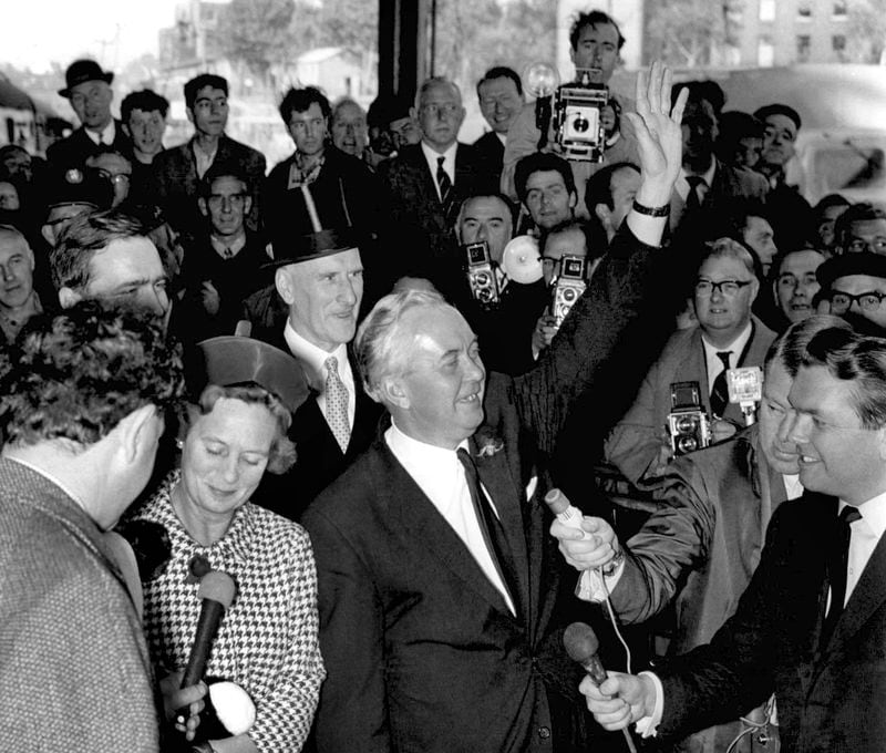 FILE - Britain's Labour Party leader Harold Wilson waves as he and his wife arrive at Euston Station, London, from his constituency in Liverpool, Oct. 16, 1964. Britain’s upcoming general election on July 4, 2024 is widely expected to lead to a change of government for the first time in 14 years. In 1964, the Conservative Party had been in power for 13 years and was on its fourth prime minister. The election was a race between the aristocratic Douglas-Home and Labour leader Harold Wilson, a young politician who was buzzing with ideas such as the need to harness the “white heat of technology” to modernize the ailing British economy. (AP Photo/File)