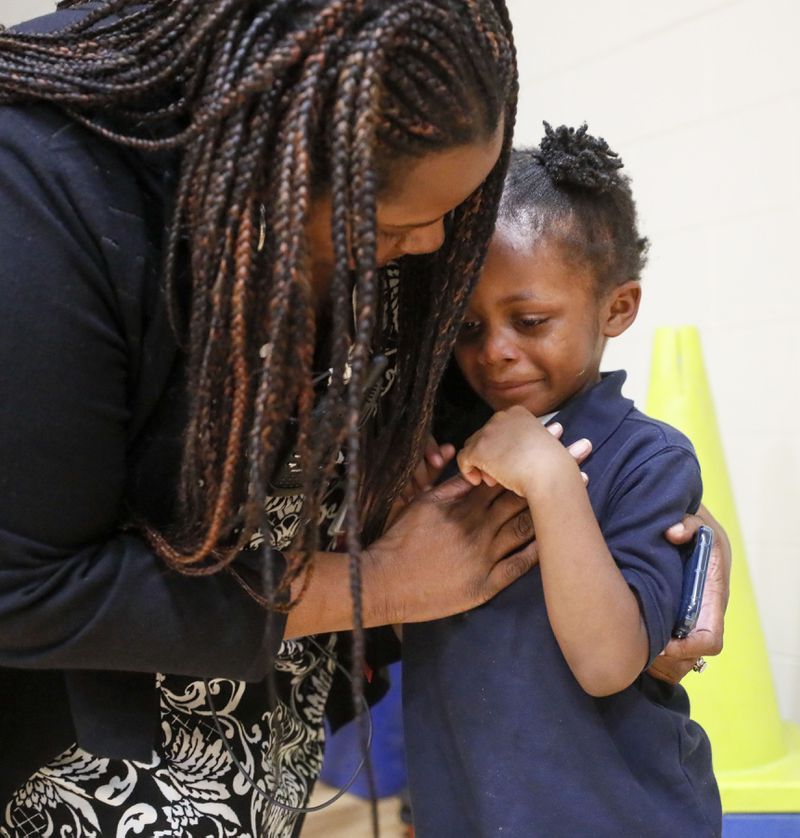 Harper-Archer Elementary School Principal Dione Simon Taylor comforts a student who got hit by a ball during the monthly "Gym Jam," an event to reward students who have earned enough points to attend on Oct. 24, 2019. Bob Andres / robert.andres@ajc.com