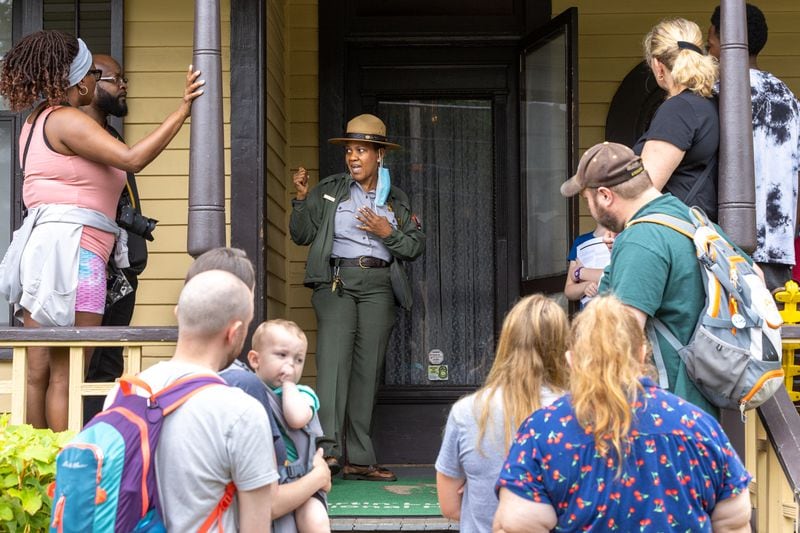 Park Ranger Selene Daniel leads a tour group outside of the birth home of Martin Luther King Jr. in Atlanta on Juneteenth, Monday, June 19, 2023. (Arvin Temkar / arvin.temkar@ajc.com)