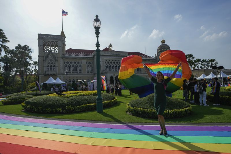 A participant holds a rainbow flag at government house in Bangkok, Thailand, Tuesday, June 18, 2024. Thailand’s Senate voted overwhelmingly on Tuesday to approve a marriage equality bill, clearing the last legislative hurdle for the country to become the first in Southeast Asia to enact such a law. (AP Photo/Sakchai Lalit)