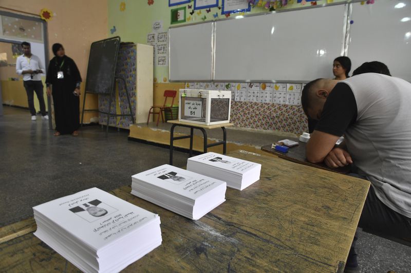 Election officials wait for voters inside a polling station during the presidential election, Saturday, Sept. 7, 2024, in Algiers, Algeria. (AP Photo/Fateh Guidoum)