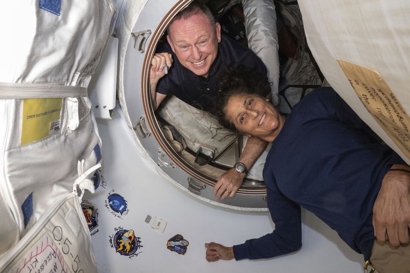 In this photo provided by NASA, Boeing Crew Flight Test astronauts Butch Wilmore, left, and Suni Williams pose for a portrait inside the vestibule between the forward port on the International Space Station's Harmony module and Boeing's Starliner spacecraft on June 13, 2024. (NASA via AP)