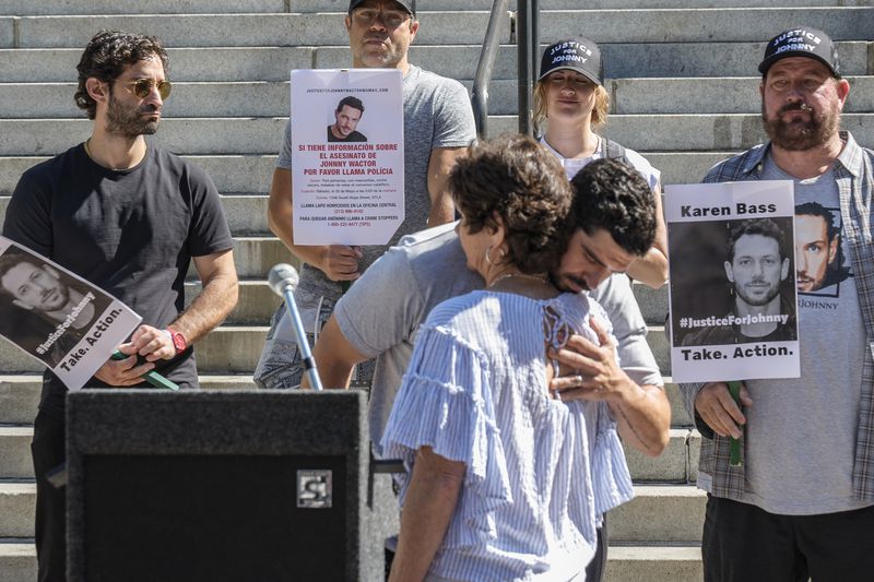 Micah Parker "Vampire Diaries," actor, producer, and organizer of Justice for Johnny Wactor, hugs Johnny's mother, Scarlett Wactor, during a news conference outside Los Angeles City Hall demanding Los Angeles Mayor Karen Bass take immediate action to find the suspects that murdered the former "General Hospital" actor, in Los Angeles, Tuesday, Aug. 13, 2024. (AP Photo/Damian Dovarganes)