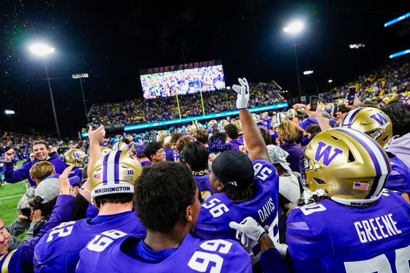 Washington players celebrate on the field after a 27-17 win over Michigan in an NCAA college football game Saturday, Oct. 5, 2024, in Seattle. (AP Photo/Lindsey Wasson)