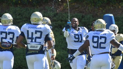 Georgia Tech defensive lineman Kelton Dawson (91) cools off with a splash of bottled water. HYOSUB SHIN / HSHIN@AJC.COM