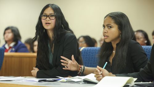 In a mock trial, defense attorneys Kaitlyn Lambert (left) and Chloe Moore (right) react to a statement from the prosecution team during the Junior District Attorney and Investigator Mentorship Program at the Gwinnett County Justice and Administration Center, Tuesday, June 25, 2024, in Lawrenceville. (Jason Getz / AJC)