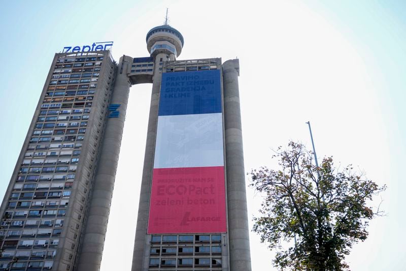 A giant French national flag on a skyscraper that is a symbolic gateway leading into the city from the airport, in Belgrade, Serbia, Thursday, Aug. 29, 2024. French President Emmanuel Macron starts a two-day state visit to Serbia on Thursday. (AP Photo/Darko Vojinovic)