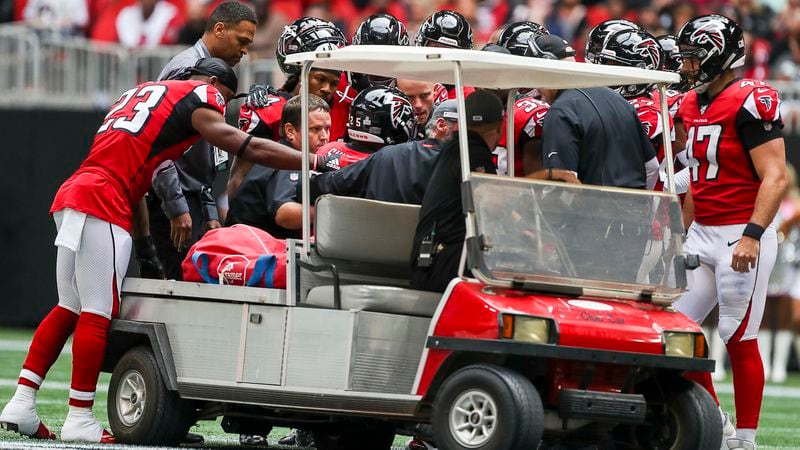Falcons players huddle around teammate Ito Smith (25) as he is taken off the field following a head-to-head hit during the first half Sunday, Oct. 20, 2019, against the Los Angeles Rams at Mercedes-Benz Stadium in Atlanta.