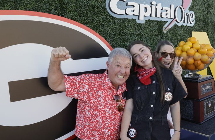 Danny Everett (left), UGA student Grace Everett and her mom, Chris Everett from Buford, pose for a photo at fan fest pregame at the 2021 College Football Playoff Semifinal between the Georgia Bulldogs and the Michigan Wolverines at the Orange Bowl at Hard Rock Stadium in Miami Gardens.   Bob Andres / bandres@ajc.com