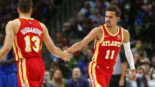 Atlanta Hawks guards Trae Young (11) gives congrats to teammate Bogdan Bogdanovic (13) during the second half of an NBA basketball game against the Dallas Mavericks in Dallas, Sunday, Feb. 6, 2022. (AP Photo/LM Otero)