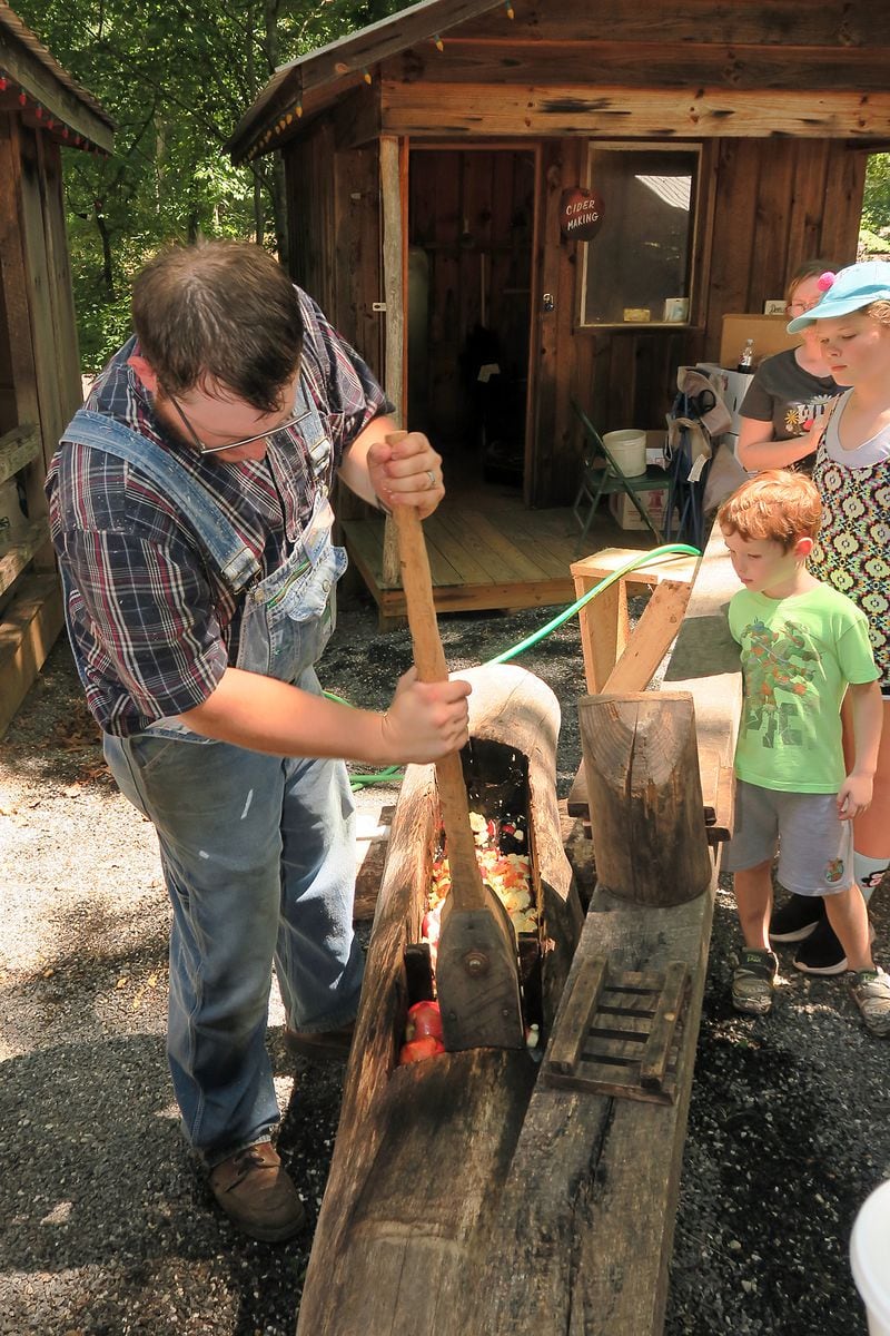 A youngster learns all about apple squeezing at the Georgia Mountain Fall Festival.