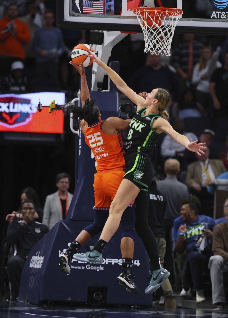 Connecticut Sun forward Alyssa Thomas (25) shoots while Minnesota Lynx forward Alanna Smith (8) defends during the second half of Game 2 of a WNBA basketball semifinals game, Tuesday, Oct. 1, 2024, in Minneapolis. (AP Photo/Adam Bettcher)