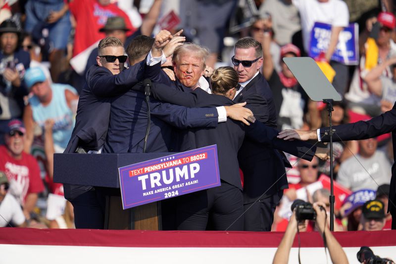 Republican presidential candidate former President Donald Trump is surround by U.S. Secret Service agents at a campaign event in Butler, Pa., Saturday, July 13, 2024. (AP Photo/Gene J. Puskar)