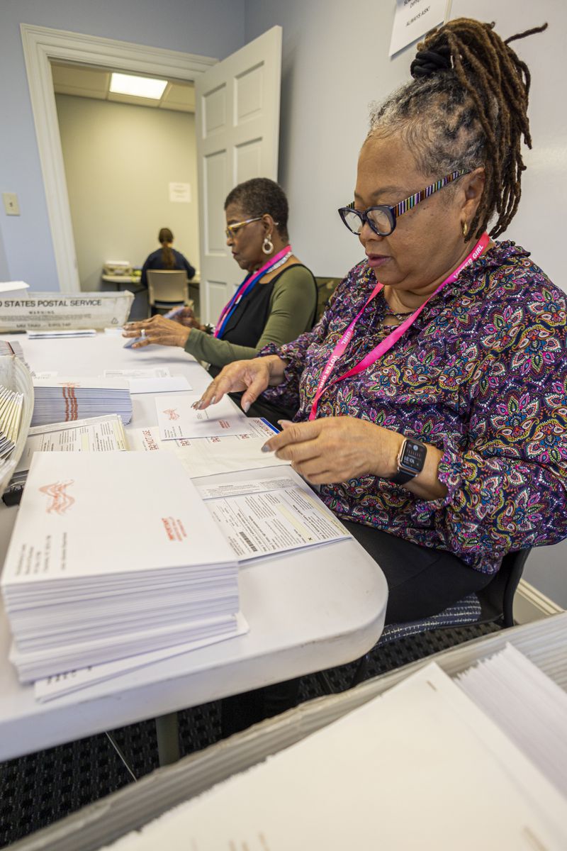 Cristo Carter, right, and Carol Hamilton put ballots in envelopes at the Mecklenburg County Board of Elections in Charlotte, N.C., Thursday, Sept. 5, 2024. (AP Photo/Nell Redmond)