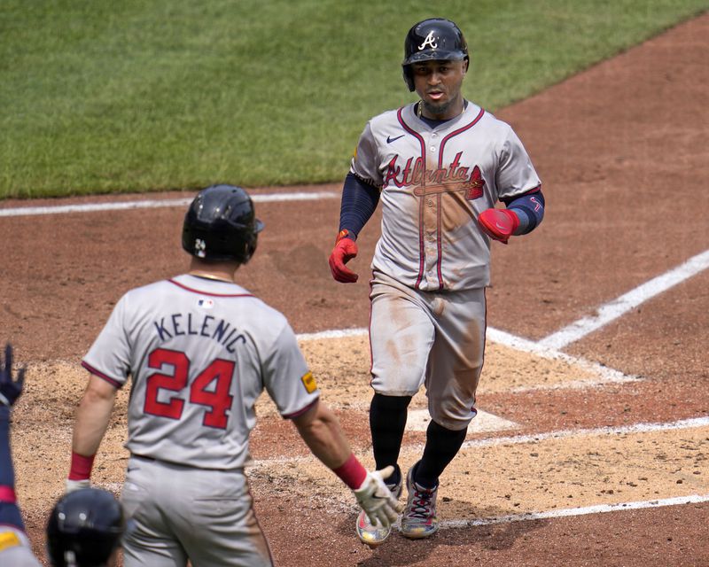Atlanta Braves' Ozzie Albies, right, is greeted by Jarred Kelenic (24) after both scored on a double by Matt Olson off Pittsburgh Pirates relief pitcher Carmen Mlodzinski during the fifth inning of a baseball game in Pittsburgh, Sunday, May 26, 2024. (AP Photo/Gene J. Puskar)