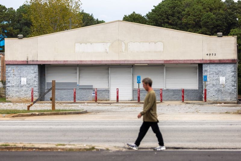 A pedestrian passes a former Family Dollar along Glenwood Road near its intersection with Columbia Drive in southern DeKalb County on Wednesday, Sept. 25, 2024. (Arvin Temkar / AJC)