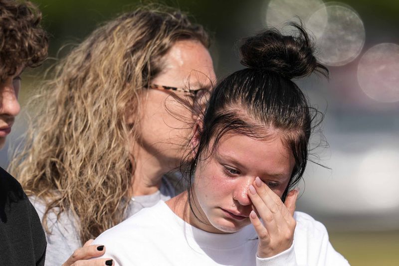 A student weeps at a makeshift memorial after a shooting Wednesday at Apalachee High School, Thursday, Sept. 5, 2024, in Winder, Ga. (AP Photo/Mike Stewart)