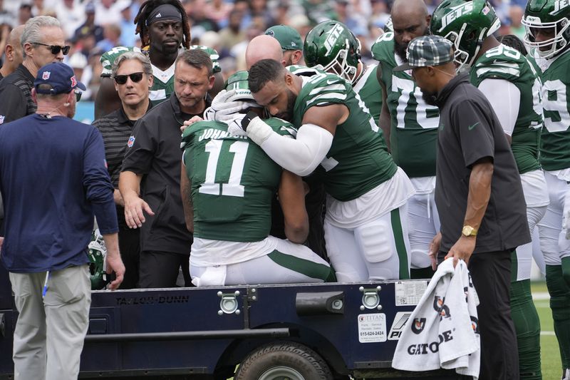 New York Jets defensive end Solomon Thomas (94) hugs New York Jets linebacker Jermaine Johnson (11) as he is taken off the field in the second half of an NFL football game against the Tennessee Titans in Nashville, Tenn., on Sunday, Sept. 15, 2024. (AP Photo/George Walker IV)