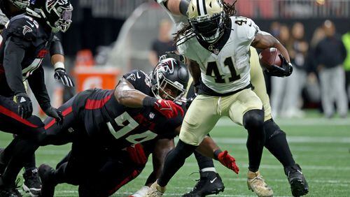 Saints running back Alvin Kamara eludes the tackle of Falcons defensive tackle Anthony Rush earlier this year in Atlanta. Rush signed with the Falcons on Thursday. (JASON GETZ FOR THE ATLANTA JOURNAL-CONSTITUTION)