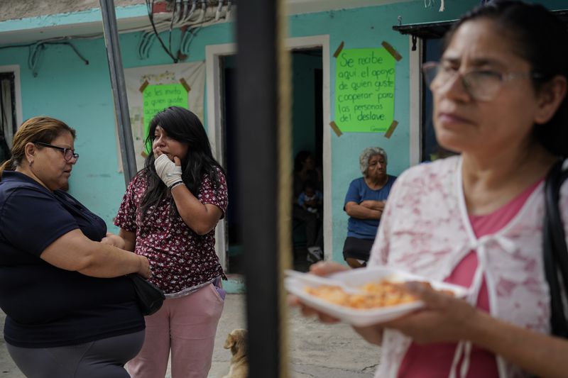 Estrella Bejarano, second from left, the mother of two children who died after a rain-induced landslide, speaks with relatives in Naucalpan, Mexico, Tuesday, Sept. 17, 2024. (AP Photo/Felix Marquez)