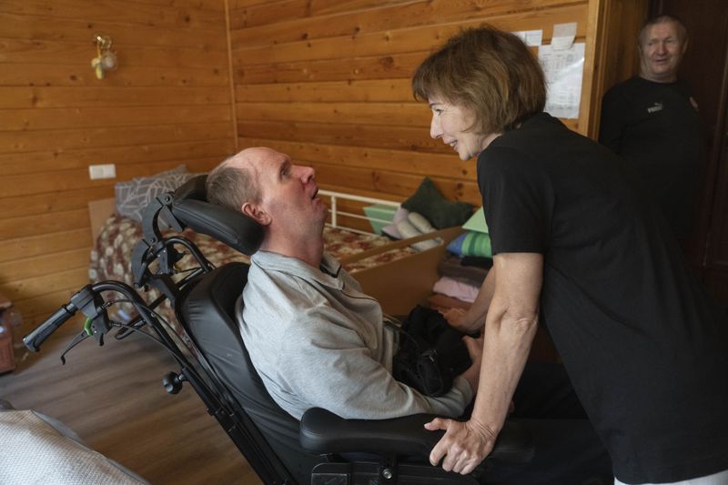 Volunteer Iryna Tymofeyeva talks to Vitalii Shumei, 36, a Ukrainian officer heavily wounded in a battle with Russian forces, at the rehabilitation center in Modrychi, Western Ukraine, Wednesday, Aug. 28, 2024. (AP Photo/Efrem Lukatsky)