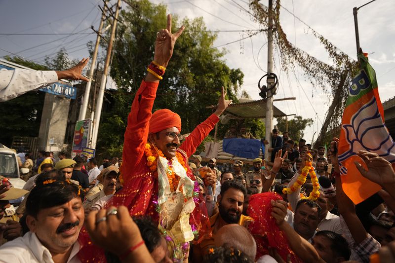 Bharatiya Janata Party (BJP) candidate Mohan lal bhagat greets supporters after victory in Jammu, India, Tuesday, Oct. 8, 2024. (AP Photo/Channi Anand)