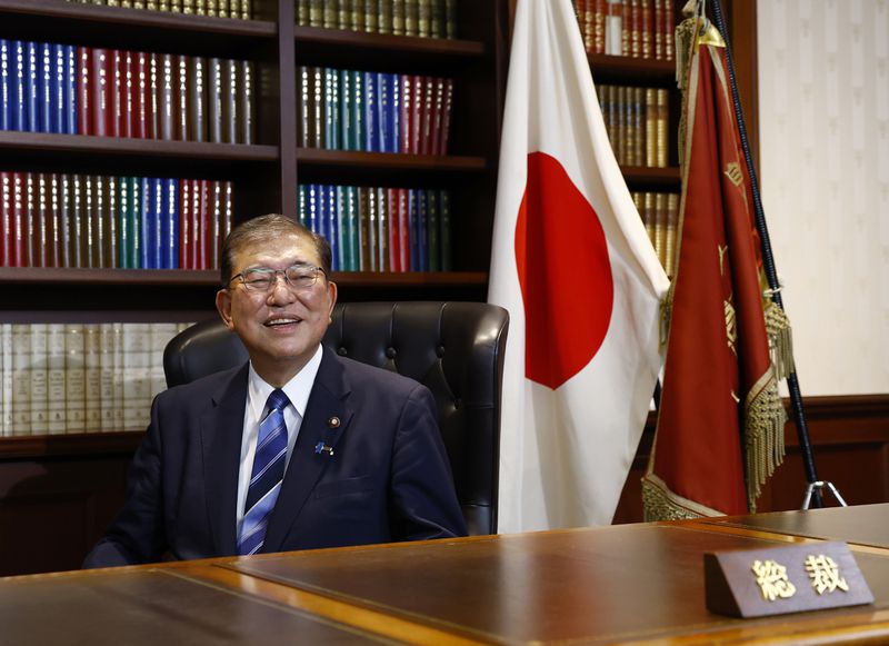 Shigeru Ishiba, the newly elected leader of Japan's ruling party, the Liberal Democratic Party (LDP) poses in the party leader's office after the LDP leadership election, in Tokyo Friday, Sept. 27, 2024. (Kim Kyung-Hoon/Pool Photo via AP)