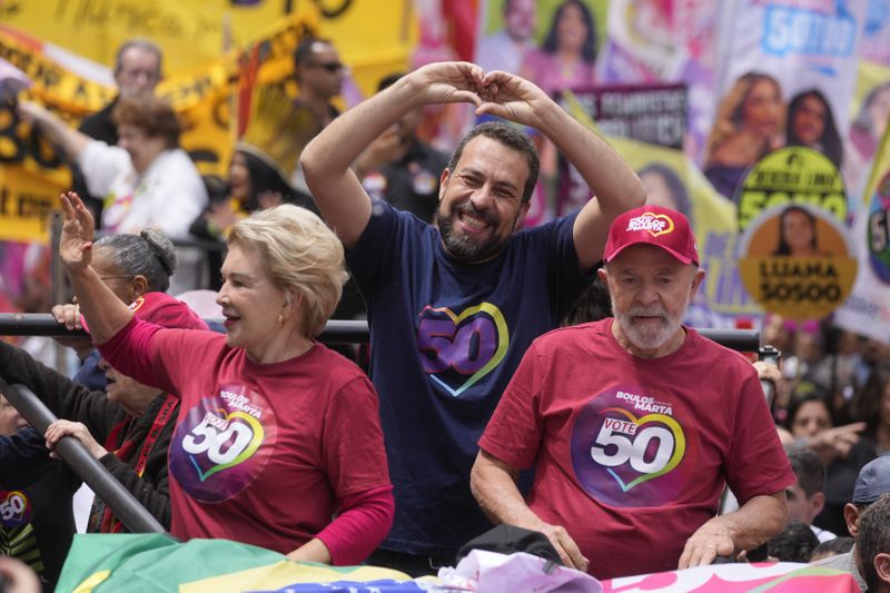 Mayoral candidate Guilherme Boulos of the Socialism and Liberty Party, center, gestures to supporters as he campaigns with Brazilian President Luiz Inacio Lula da Silva, right, and his running mate Marta Suplicy, left, the day before elections in Sao Paulo, Saturday, Oct. 5, 2024. (AP Photo/Andre Penner)