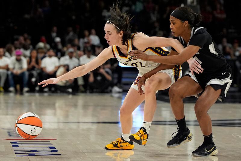 Indiana Fever guard Caitlin Clark (22) and Las Vegas Aces guard Sydney Colson (51) vie for the ball during the second half of a WNBA basketball game Saturday, May 25, 2024, in Las Vegas. (AP Photo/John Locher)