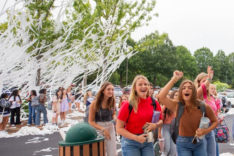 Students excitedly walk through a sea of toilet paper before going to their first day of classes in Marietta on Wednesday, Aug. 2, 2023. Following with tradition, the new seniors of Marietta High School TPed their school the night before the first day. (Katelyn Myrick/katelyn.myrick@ajc.com)