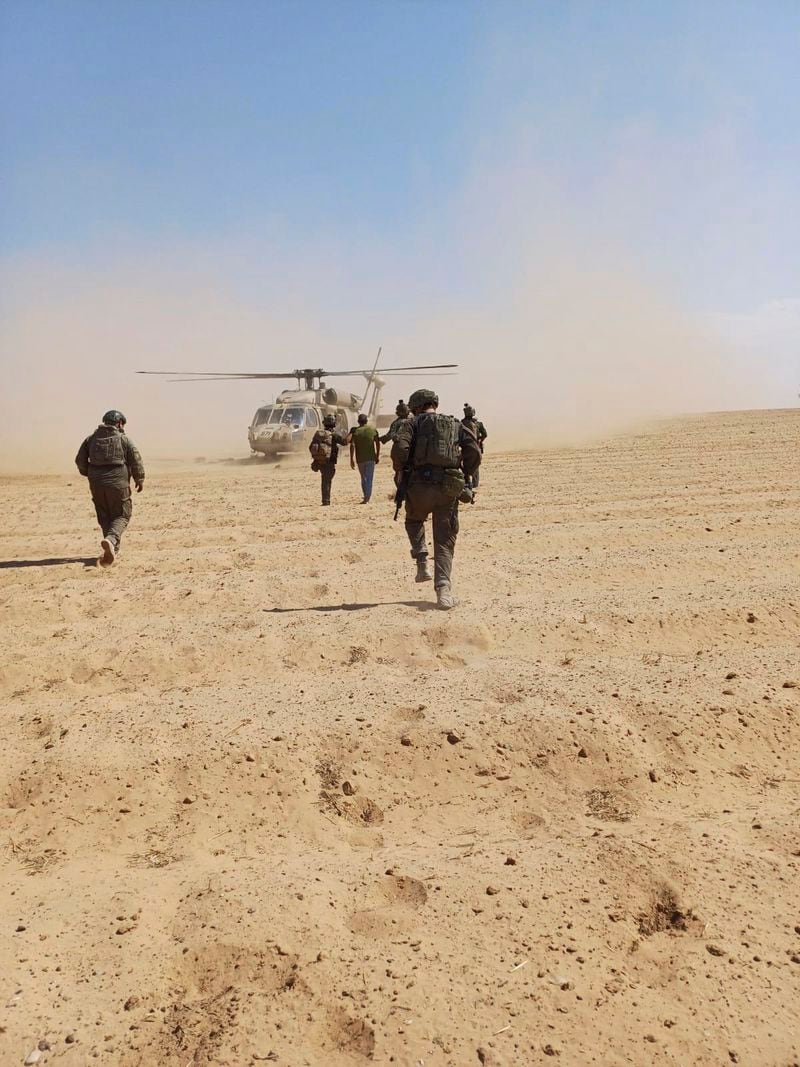 In this photo released by Israeli Defense Forces on Tuesday, Aug. 27, 2024, Israeli soldiers walk with Qaid Farhan Alkadi toward a military helicopter during the rescue operation. (Israeli Defense Forces via AP)